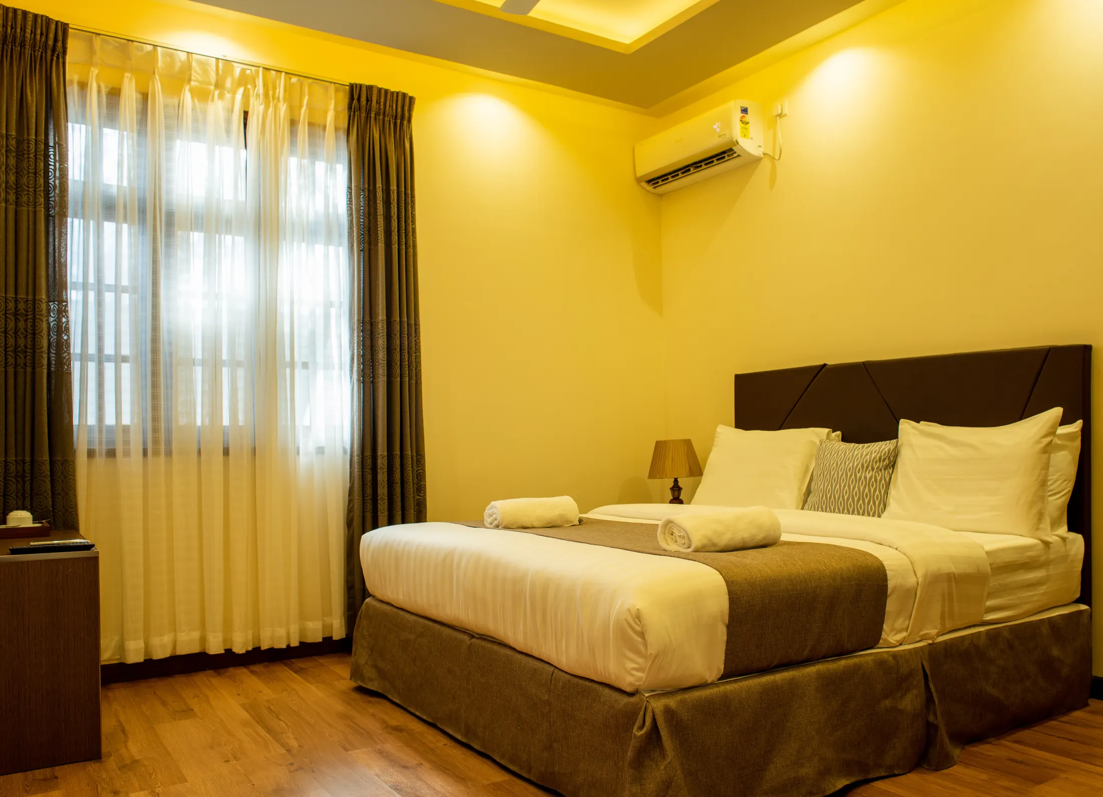 A double room with warm lighting and tall windows