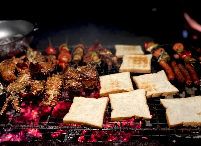 Lobster, fish and bread on a beach barbecue